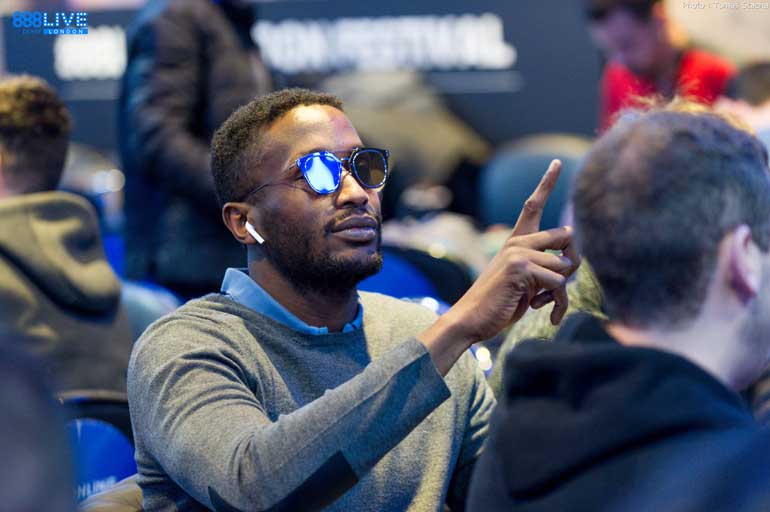 Homem de óculos gesticula à mesa de poker